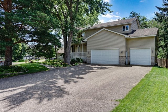 5061 Oxbow Pl, Champlin, MN 55316 - view of front facade with asphalt driveway, an attached garage, a front lawn, a porch, and roof with shingles