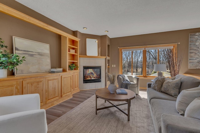 5061 Oxbow Pl, Champlin, MN 55316 - living area with wood finished floors, a tile fireplace, built in shelves, and recessed lighting
