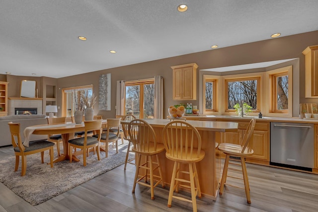 5061 Oxbow Pl, Champlin, MN 55316 - dining area featuring a fireplace, a textured ceiling, recessed lighting, and light wood finished floors