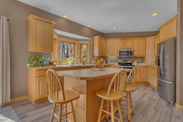 5061 Oxbow Pl, Champlin, MN 55316 - kitchen featuring stainless steel appliances, light brown cabinetry, a center island, light wood-type flooring, and recessed lighting