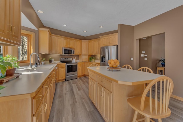 5061 Oxbow Pl, Champlin, MN 55316 - kitchen featuring stainless steel appliances, light brown cabinetry, a kitchen bar, light wood-style floors, and recessed lighting