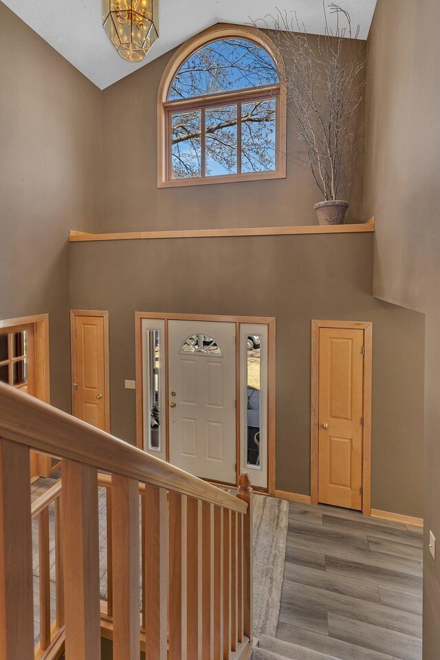 5061 Oxbow Pl, Champlin, MN 55316 - entryway with high vaulted ceiling, wood finished floors, a chandelier, and stairs