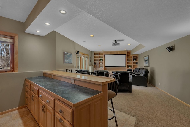 5061 Oxbow Pl, Champlin, MN 55316 - kitchen featuring dark countertops, a breakfast bar area, a peninsula, open floor plan, and built in shelves
