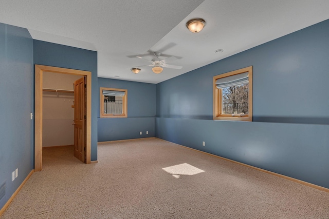 5061 Oxbow Pl, Champlin, MN 55316 - unfurnished bedroom featuring carpet flooring, a walk in closet, a closet, and a ceiling fan
