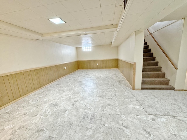 basement featuring wood walls