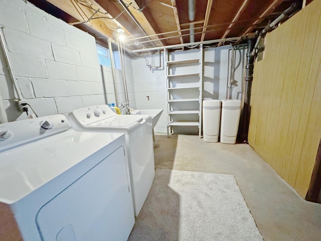 laundry room with independent washer and dryer, wood walls, and sink