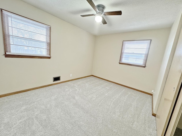 carpeted spare room with ceiling fan and a textured ceiling