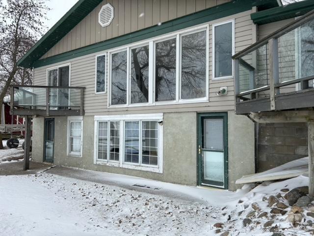 snow covered rear of property with a balcony