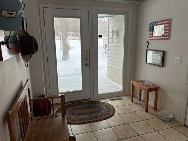 doorway to outside with light tile patterned floors