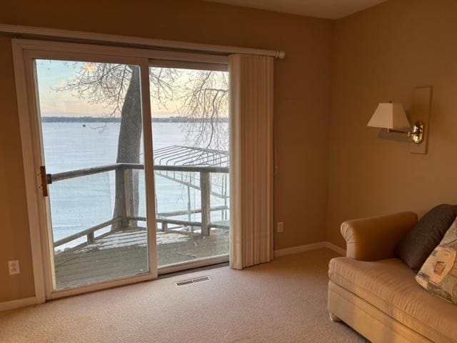 carpeted living room with a water view