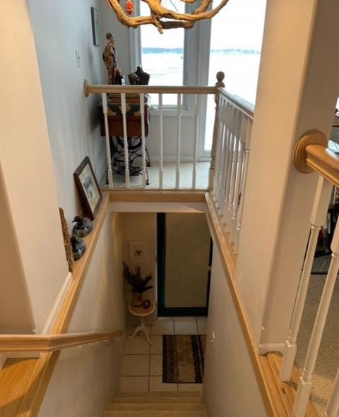 staircase featuring tile patterned floors and a chandelier