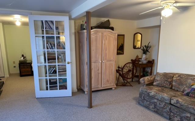 carpeted living room featuring ceiling fan