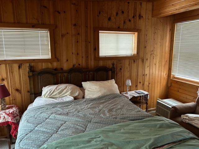 bedroom featuring wooden walls