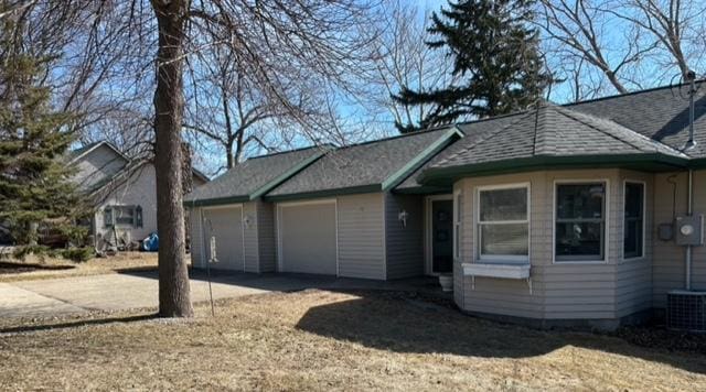 view of front of house featuring roof with shingles, driveway, and an attached garage