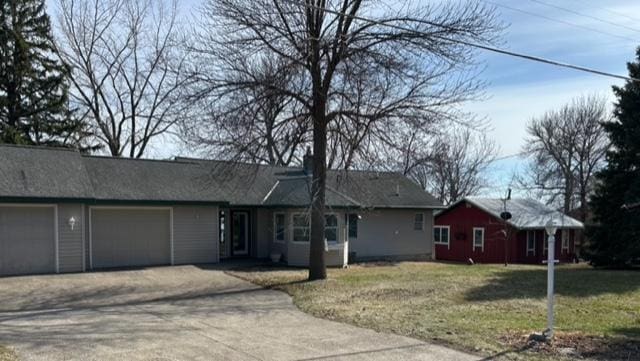 ranch-style house featuring a garage, a front yard, and dirt driveway