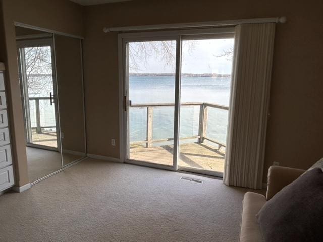 interior space with a wealth of natural light, visible vents, baseboards, and carpet floors