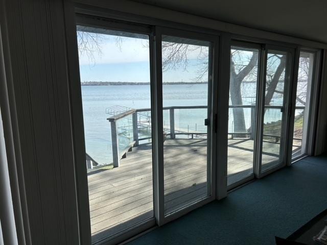 entryway with a water view and carpet floors