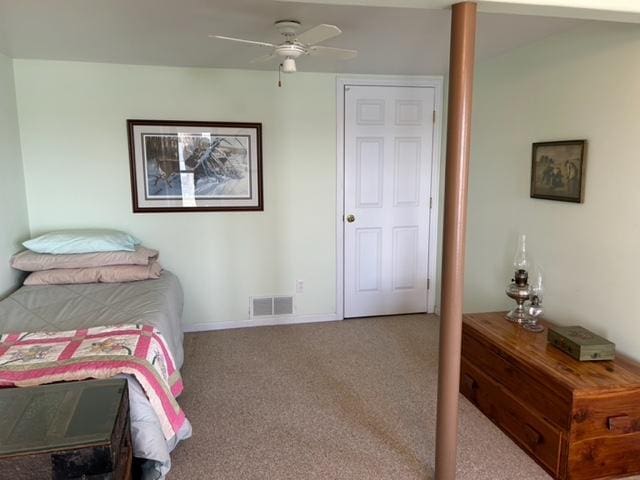carpeted bedroom with visible vents and a ceiling fan