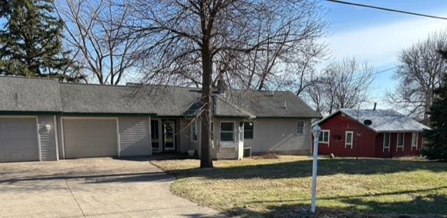 view of front facade with a front yard, driveway, and an attached garage