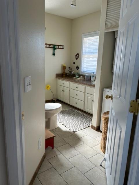 bathroom with tile patterned flooring, vanity, and toilet