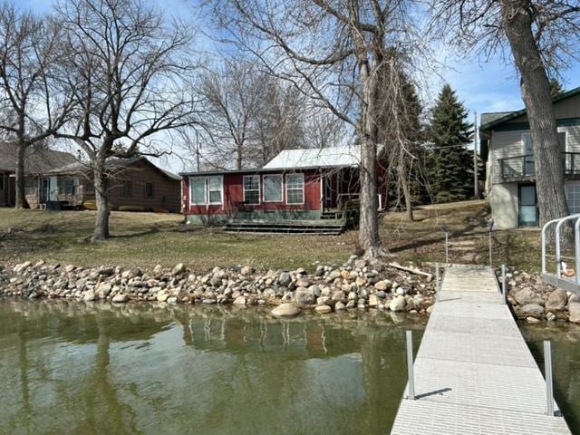 view of dock featuring a water view and a yard