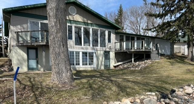 rear view of property featuring stairs and a deck