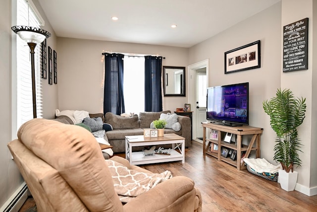 living room featuring baseboard heating and hardwood / wood-style floors