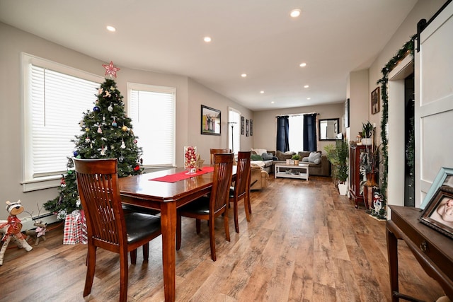 dining space featuring a barn door and light hardwood / wood-style floors