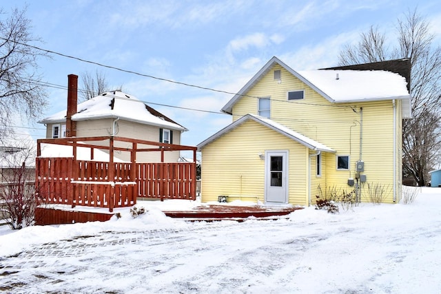 snow covered property featuring a wooden deck