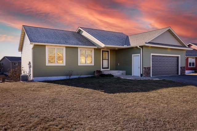 single story home with a yard, a garage, and cooling unit