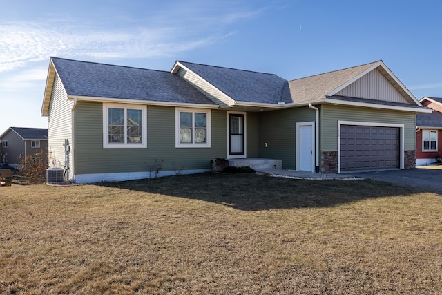 single story home with cooling unit, a front yard, and a garage