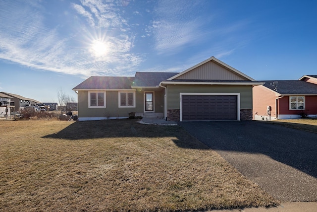 ranch-style home featuring a garage and a front yard