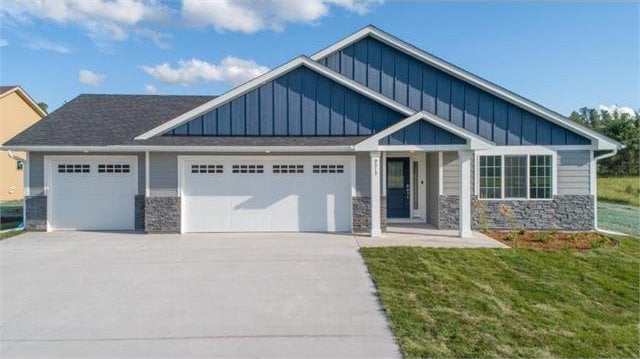 craftsman house with a garage and a front lawn