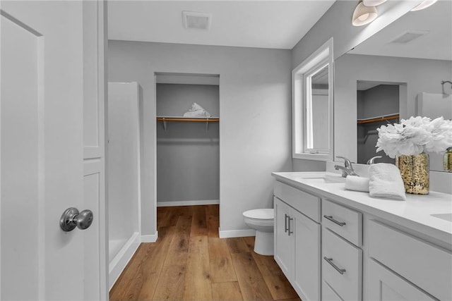 bathroom with hardwood / wood-style flooring, vanity, and toilet