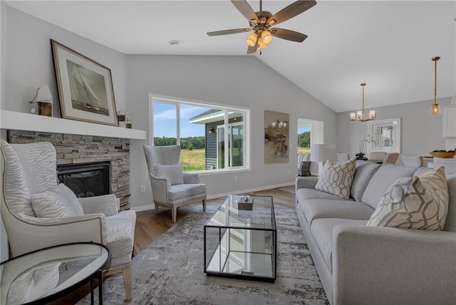 living room with a fireplace, ceiling fan with notable chandelier, light hardwood / wood-style flooring, and lofted ceiling