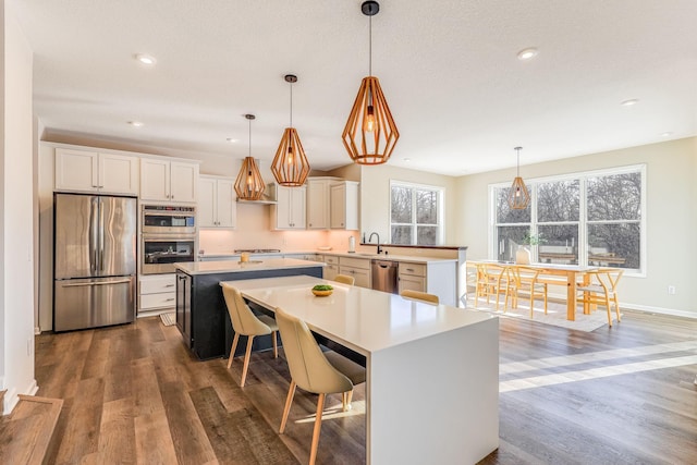 kitchen with pendant lighting, stainless steel appliances, and a kitchen island