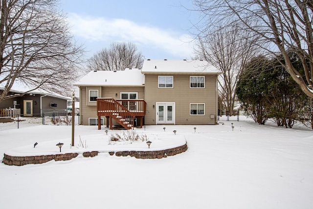 snow covered property featuring french doors and a wooden deck