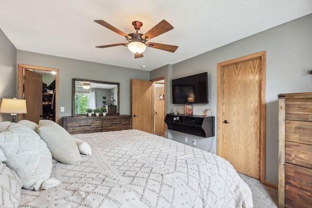 carpeted bedroom featuring ceiling fan and a closet