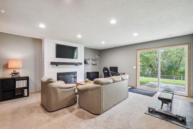 living room featuring a large fireplace, light colored carpet, and a textured ceiling