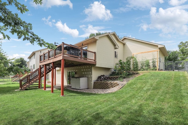 rear view of property featuring a lawn and a deck