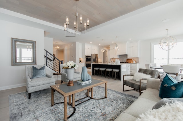 living room featuring a raised ceiling and an inviting chandelier