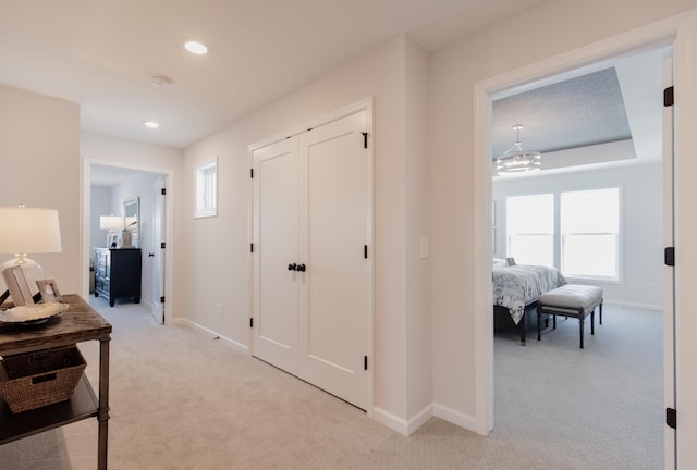 hallway featuring light colored carpet