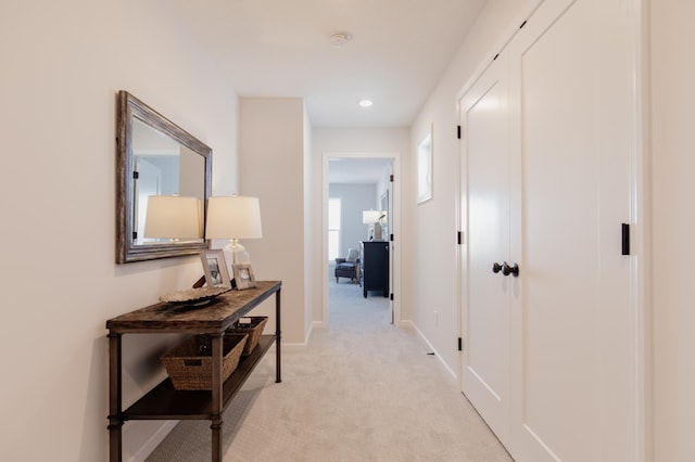 hallway featuring light colored carpet