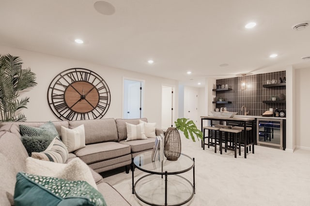 carpeted living room with beverage cooler and indoor wet bar