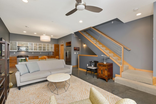 living room featuring ceiling fan and concrete flooring