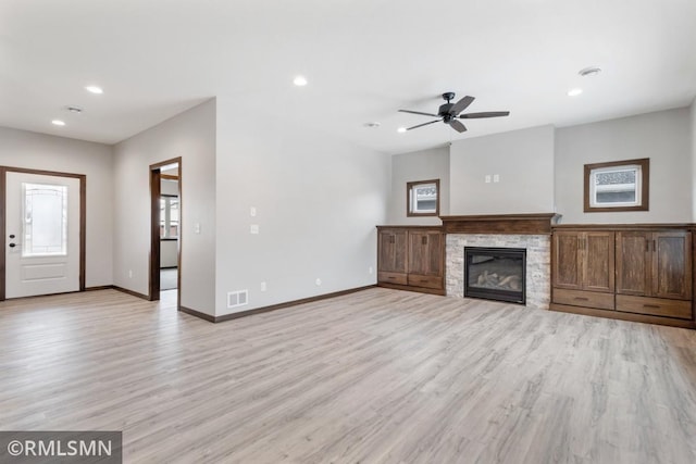 unfurnished living room featuring ceiling fan, baseboards, and light wood-style flooring