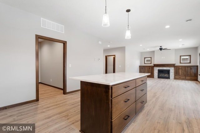 kitchen with visible vents, baseboards, light wood-style floors, and a ceiling fan