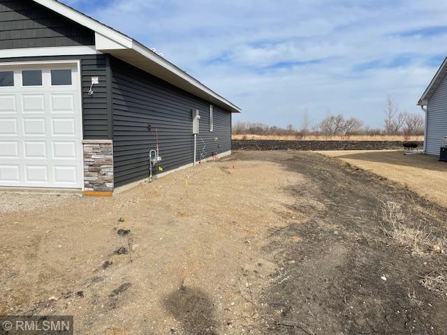 view of property exterior with a garage and stone siding