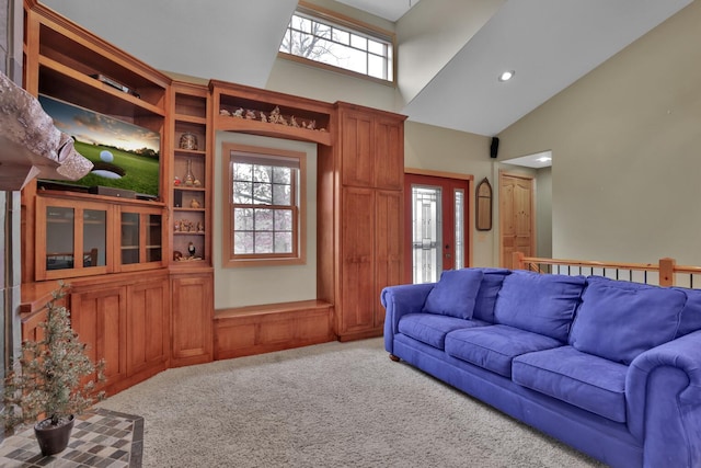 living room featuring high vaulted ceiling and carpet flooring