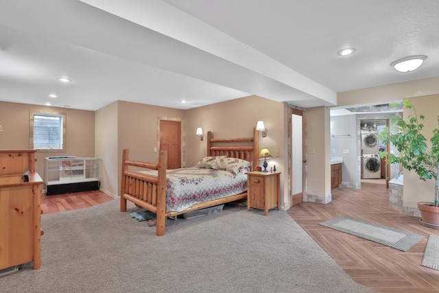 bedroom featuring light parquet flooring and stacked washer / dryer